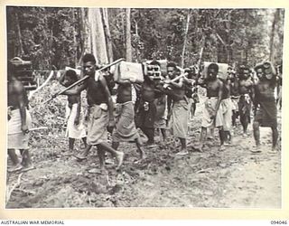 BOUGAINVILLE, 1945-07-14. NATIVE CARRIERS MOVING INTO COMPANY POSITIONS WITH MORTAR BOMBS DURING THE 15 INFANTRY BATTALION ADVANCE ALONG THE AXIS OF THE BUIN ROAD IN SOUTH BOUGAINVILLE. OFFENSIVE ..