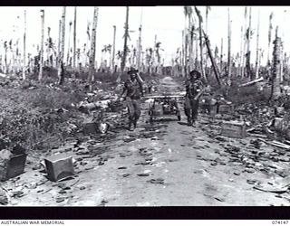 HANSA BAY, NEW GUINEA. 20 JUNE 1944. NX127827 SERGEANT J RIMMER (LEFT) AND PRIVATE STOTT (RIGHT) OF THE 4TH INFANTRY BATTALION, DRAGGING THEIR CAPTURED JAPANESE HAND CART ALONG A TRACK THROUGH A ..