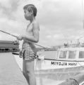 United States, boy fishing on pier in Honolulu