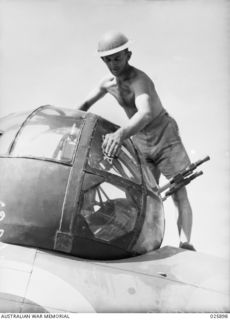 PORT MORESBY, PAPUA, 1942-07-11. THE REAR-GUNNER OF AN AUSTRALIAN LOCKHEED BOMBER AIRCRAFT POLISHING HIS GUN TURRET READY FOR THE NEXT FLIGHT. HE HAS JUST RETURNED FROM A BOMBING RAID OVER LAE, AND ..