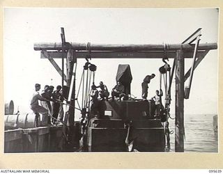 JACQUINOT BAY, NEW BRITAIN, 1945-08-31. AN AUSTRALIAN BARGE OF 53 PORT CRAFT COMPANY ROYAL AUSTRALIAN ENGINEERS, BEING LIFTED FROM THE WATER FOR RUDDER REPAIRS