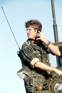 A forward air controller, using a radio, directs an F-4 Phantom II aircraft toward a bomb target. The controller is from the 22nd Tactical Air Support Squadron, involved in Exercise Opportune Journey 4