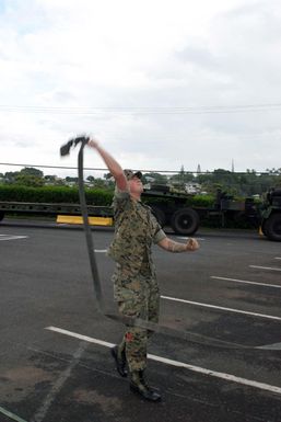 US Marine Corps (USMC) Lance Corporal (LCPL) Spangler, assigned to Combat Service Support Group 3 (CSSG-3), Marine Forces Pacific (MARFORPAC) tosses a tie down strap across the load as he uploads a Combat Camera and Printing (CC&P) air conditioning unit onto a transport truck at Camp H.M. Smith, Hawaii (HI), as the Unit prepares for deployment to Iraq, in support of Operation IRAQI FREEDOM