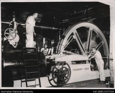 Workers operating mill machinery