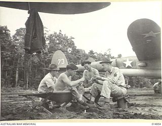 1943-05-17. SOMEWHERE IN NEW GUINEA. AIRCRAFT GROUND CREW SIT IN ON A GAME OF CARDS. LEFT TO RIGHT CORP. RALPH LOFTIN (NORTH CAROLINA; CORP. W.H. POTEET (MISSOURI); CORP DEWEY REID (NORTH CAROLINA) ..