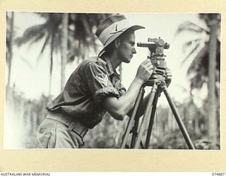 MILILAT, NEW GUINEA. 1944-07-22. NX95251 BOMBARDIER K.L. LUTHERBORROW, 5TH SURVEY BATTERY, TAKING A READING THROUGH A TYPE T63, THEODOLITE DURING THE SURVEY OF THE MILILAT SECTION OF THE ..