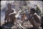 Land clearing: men smoke next to fire burning away cut trees and bushes