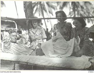 AITAPE, NEW GUINEA. 1945-02-20. MISS PAULINE GARRICK (3) AND MISS MAMIE READ (4) OF THE DICK BENTLEY CONCERT PARTY CHATTING WITH SX19061 CRAFTSMAN G. MUDGE (1) A PATIENT IN THE 104TH CASUALTY ..