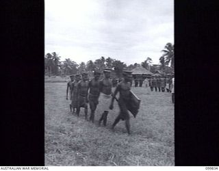 LAE, NEW GUINEA, 1946-02-14. AT A SPECIAL PARADE, MAJOR GENERAL B.M. MORRIS, GENERAL OFFICER COMMANDING AUSTRALIAN NEW GUINEA ADMINISTRATIVE UNIT, PRESENTED GIFTS (FRAMED COLOURED PHOTOGRAPHS OF ..