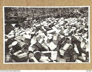 FINSCHHAFEN, NEW GUINEA. 1943-11-20. GENERAL VIEW OF THE AUSTRALIAN ARMY SUPPLY DUMP, SHOWING NX51358 CORPORAL J. DAY AT WORK SORTING CASES OF SUPPLIES