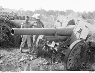 LAE, NEW GUINEA. C. 1944-02. SQUADRON LEADER C. TREWEN, SYDNEY, NSW (LEFT), AND FLYING OFFICER N. BARTLETT, PERTH, WA, LOOKING AT A JAPANESE GUN CAPTURED BY THE AIF AT LAE