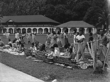 [Group of Pacific Island people sitting with crafted objects]