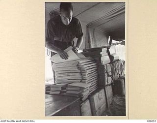 CAPE WOM, NEW GUINEA. 1945-10-17. CORPORAL K.G. HOWE, OF THE DEMOBILIZATION SECTION AT HEADQUARTERS 6 DIVISION, COUNTING THROUGH NEWLY ARRIVED MEDICAL STATIONERY. THE INCREASING ACTIVITIES OF THE ..