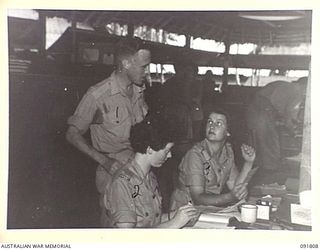 LAE, NEW GUINEA. 1945-05-15. PRIVATE E. PECK (2), AND PRIVATE M.E. NEGAS (3), HANDLING INWARD AND OUTWARD CORRESPONDENCE AT HEADQUARTERS FIRST ARMY. PRIVATE L.A. STATON (1) IN BACKGROUND. A FEW ..