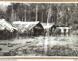 WAU AREA, NEW GUINEA, 1943-08-15. THE SUMMIT STAGING CAMP, SHOWING FROM LEFT TO RIGHT, ORDERLY ROOM, REGIMENTAL AID POST, YOUNG MENS CHRISTIAN ASSOCIATION HUT AND KITCHEN. THE CAMP IS STAFFED BY ..