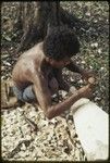 Canoe-building: man carves nipawa (grasshopper) design on prow