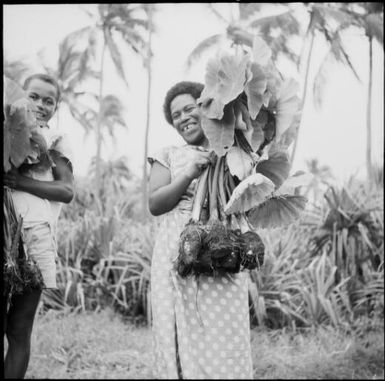 Woman and child holding harvested taro plants, Fiji, 1966 / Michael Terry
