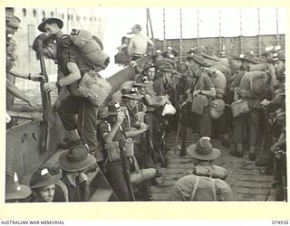 SIAR, NEW GUINEA. 1944-07-25. TROOPS OF THE 61ST INFANTRY BATTALION, MOVING INTO A LANDING BARGE FROM THE PONTOON AFTER DISEMBARKING FROM THE TRANSPORT SHIP (TS) "KATOOMBA". IDENTIFIED PERSONNEL ..