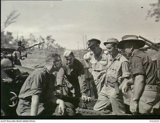 TOROKINA, BOUGAINVILLE ISLAND, SOLOMON ISLANDS. 1945-01-28. ANZACS REUNITED. ARTILLERY OFFICERS EXPLAINING THE INTRICACIES OF A 25 POUNDER GUN TO RAAF AND ROYAL NEW ZEALAND AIR FORCE PILOTS. LEFT ..