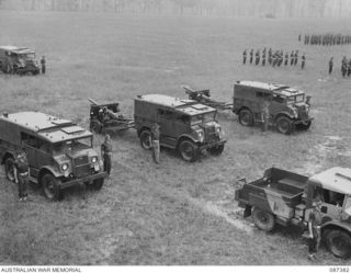 HERBERTON, QUEENSLAND. 1945-03-03. 24 BATTERY, 2/12 FIELD REGIMENT TROOPS BESIDE THEIR VEHICLES DURING A PARADE AT THE HERBERTON RACECOURSE. MAJOR GENERAL G.F. WOOTTEN, GENERAL OFFICER COMMANDING 9 ..