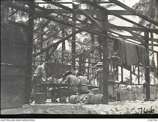 MOMOTE, LOS NEGROS ISLAND, ADMIRALTY ISLANDS. 1944-03-08. RAAF KITTYHAWK PILOTS EATING THEIR LUNCH IN A PARTLY ERECTED CREW-ROOM NEAR THE AIRSTRIP. THEY ARE READY TO DROP THEIR FOOD AND TAKE OFF AT ..