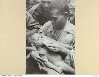1943-09-25. NEW GUINEA. FALL OF LAE. LEAH FIFTEEN YEARS OLD NATIVE GIRL WITH A SIX MONTHS OLD BABY. LEAH ESCAPED FROM THE JAPANESE LINES JUST BEFORE THE FALL OF LAE
