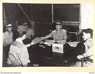 TOROKINA, BOUGAINVILLE, 1945-08-20. CAPTAIN TAKENAKA (1), ENVOY FROM LIEUTENANT-GENERAL M. KANDA, COMMANDER 17 JAPANESE ARMY GROUP, RECEIVING WRITTEN INSTRUCTIONS FOR DELIVERY TO HIS SUPERIORS FROM ..