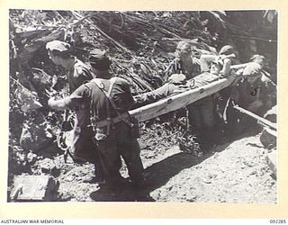 BOUGAINVILLE. 1945-05-17. PRIVATE M.H. PRATT, C COMPANY, 57/60 INFANTRY BATTALION (3), A BATTLE CASUALTY, BEING CARRIED ON A STRETCHER UP THE BANKS OF THE HUDA RIVER DURING THE ADVANCE BY 57/60 ..
