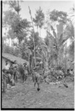 Returned laborers, purification ritual: laborers (left) by house they have built