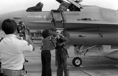 Upon his arrival in Hawaii, the pilot of this Air Force F-16A Fighting Falcon aircraft who has just landed, receives the traditional ring of flowers around his neck and a kiss from a pretty lady. The F-16A is from the 428th Tactical Fighter Squadron located at Nellis Air Force Base, Nevada, and is here to fly with Marine F-4 Phantom aircraft in support of Hawaii-based Army units. The event is a Joint Chiefs of STAFF exercise, which will last for one month (2 Oct to 2 Nov 1981)