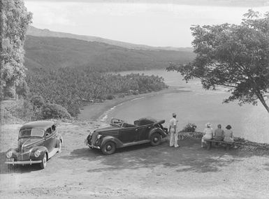 [View of a group of people and two vehicles]