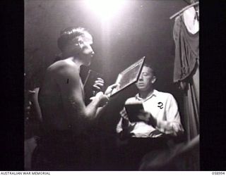 KONEDOBU (KANEDABU), NEW GUINEA. 1943-10-27. MEMBERS OF THE 7TH AUSTRALIAN DIVISION CONCERT PARTY MAKING UP IN THEIR TENT BEFORE THE SHOW. SHOWN: QX11740 PRIVATE J. J. GARNER (1); VX121283 CORPORAL ..