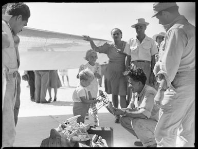 Man giving present to boy, Aitutaki airfield