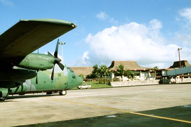 A 374th Tactical Airlift Wing C-130 Hercules aircraft stands on the flight line after delivering Christmas Drop packages for Micronesian island people evacuated to Saipan because of a typhoon. The annual airdrop is humanitarian effort providing aid to needy islanders throughout Micronesia during the holiday season