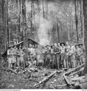 PAPUA. 1942-09. SAPPERS OF THE 2/6TH FIELD COMPANY, ROYAL AUSTRALIAN ENGINEERS, TAKE TIME OUT FOR A CUP OF TEA. THEY ARE ENGAGED ON BUILDING UP, WIDENING AND STRENGTHENING THE NATIVE PATHS ACROSS ..