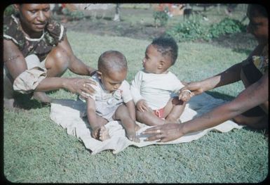 Children of dokta bois babies sitting on a rug, Basil on left and Johannes on right : Minj Station, Wahgi Valley, Papua New Guinea, 1954 / Terence and Margaret Spencer