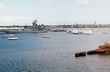 A port bow view of the battleship USS NEW JERSEY (BB-62) passing the USS ARIZONA Memorial