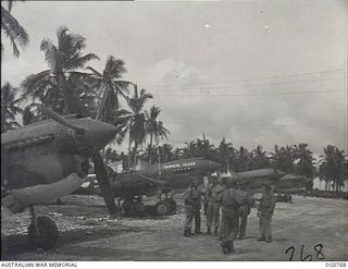 MOMOTE, LOS NEGROS ISLAND, ADMIRALTY ISLANDS. 1944-03-08. KITTYHAWK AIRCRAFT OF NO. 76 SQUADRON RAAF ON STAND-BY AT MOMOTE AIRSTRIP, BESIDE THE COCONUT PALM TREES, SCENE OF THE ORIGINAL LANDING IN ..