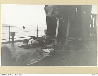 MADANG AREA, NEW GUINEA. 1944-05-14. IN THE LIGHT OF DAWN, GUNNERS, PREPARED FOR EMERGENCY, SLEEP ALONGSIDE A 4 INCH GUN ABOARD HMAS KAPUNDA. THE SHIP, ANCHORED IN HARBOUR, HAS RETURNED FROM A ..