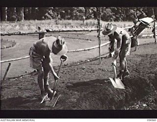 SOPUTA, NEW GUINEA, 1943-07-20. VX21024 CORPORAL (CPL) G. A. C. MURPHY (LEFT) AND VX78574 CPL K. W. JOSLIN OF THE 15TH AUSTRALIAN WAR GRAVES REGISTER AND ENQUIRY UNIT, DIGGING A GARDEN BED AT THE ..