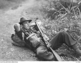 WEWAK AREA, NEW GUINEA. 1944-05-26. NX101819 PRIVATE J. GOODSALL, 35TH INFANTRY BATTALION (1), RESTING ON THE TRACK DURING THE DRIVE UP THE COAST TO WEWAK. HE HAS COMPLETED A PERIOD OF FORWARD ..