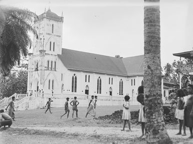 [Several Pacific island people outside a large church]