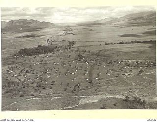 DUMPU, RAMU VALLEY, NEW GUINEA, 1944-02-10. AN AERIAL VIEW AT 300 FEET SHOWING THE COMMAND GROUP HEADQUARTERS TENT(1) AND 7TH DIVISIONAL SIGNAL HEADQUARTERS WITH THE URIA RIVER IN THE FOREGROUND, ..