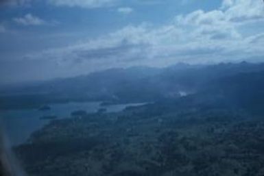 [Aerial view of forested hills and a water inlet on Fiji Island]