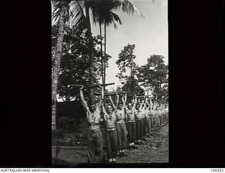 Lae, New Guinea. 1944-07-27. Members of 22 Platoon, F Company, 2/1st Guard Regiment, doing physical training exercises, holding their rifles above their heads. Front to back: Private (Pte) S. ..