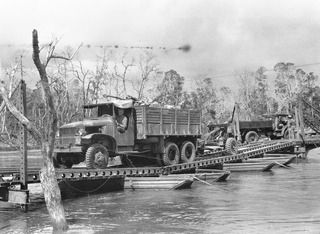 WEWAK POINT, NEW GUINEA, 1945-05-12. THE 25-POUNDER OF 2/2 FIELD REGIMENT, ROYAL AUSTRALIAN ARMY, MOVING OVER THE BRIDGE OVER MINGA CREEK ON THE ROAD TO WEWAK POINT. THIS BRIDGE WAS BUILT BY 2/8 ..