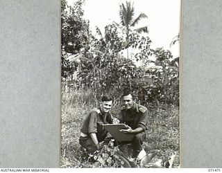 SATTELBERG AREA, NEW GUINEA. 1944-03-27. NX191007 LIEUTENANT E. A. D. WATSON (1), AND VX93432 CAPTAIN R. C. HODGKINSON (2), MILITARY HISTORY SECTION WAR ARTIST, AT WORK IN THE AREA