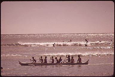 OUTRIGGER CANOES AND SURFERS AT WAIKIKI BEACH