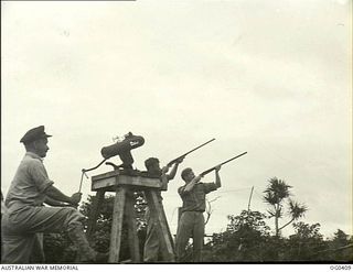 KIRIWINA, TROBRIAND ISLANDS, PAPUA. C. 1943-11-12. FIGHTER PILOTS OF NO. 76 (KITTYHAWK) SQUADRON RAAF SHOOT CLAY PIGEONS WHILE ON "STANDBY". LEFT: SERGEANT (SGT) N. W. BUTLER, HABERFIELD, NSW; SGT ..