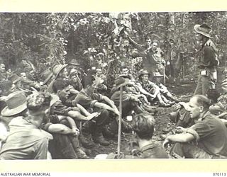 KETOBA, NEW GUINEA. 1944-01-29. VX104114 CHAPLAIN G.T SAMBELL (CHURCH OF ENGLAND) (1); UNIT PADRE OF THE 57/60TH INFANTRY BATTALION CONDUCTING AN IMPROMPTU PRAYER MEETING ON THE TRAIL NEAR BOKU ..